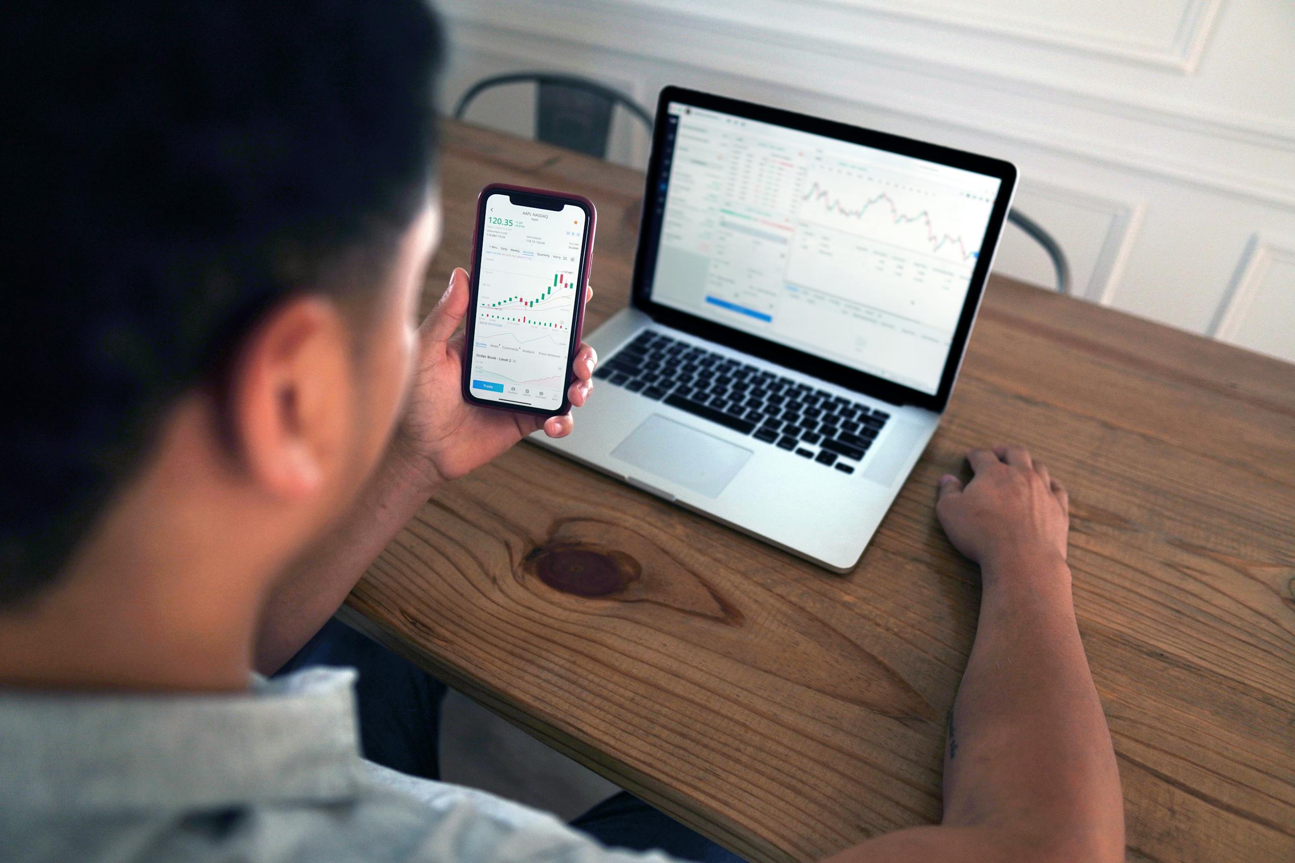 A Person Using Smartphone and Laptop